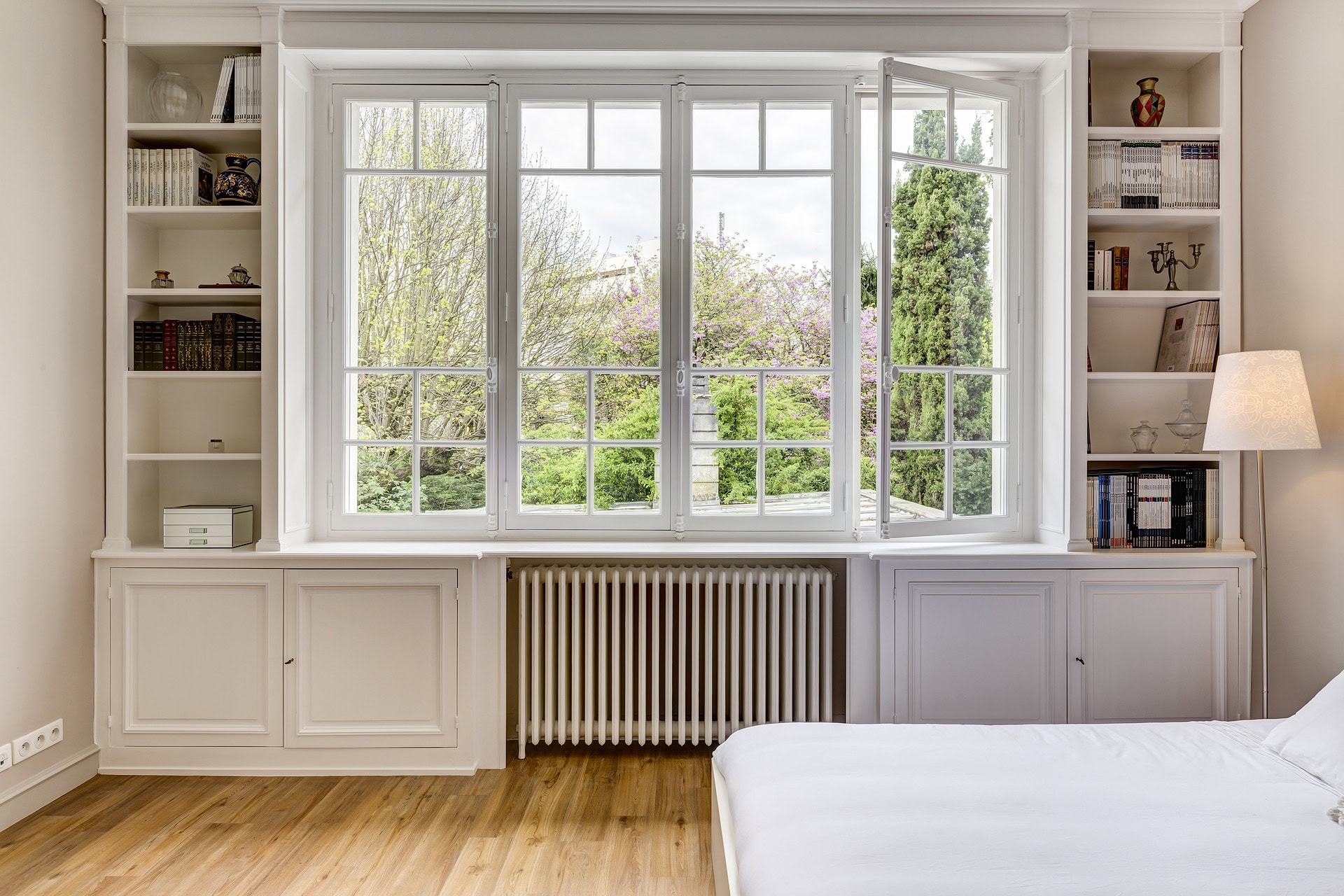 Chambre avec grande bibliothèque intégrée et fenêtre ouvrante.