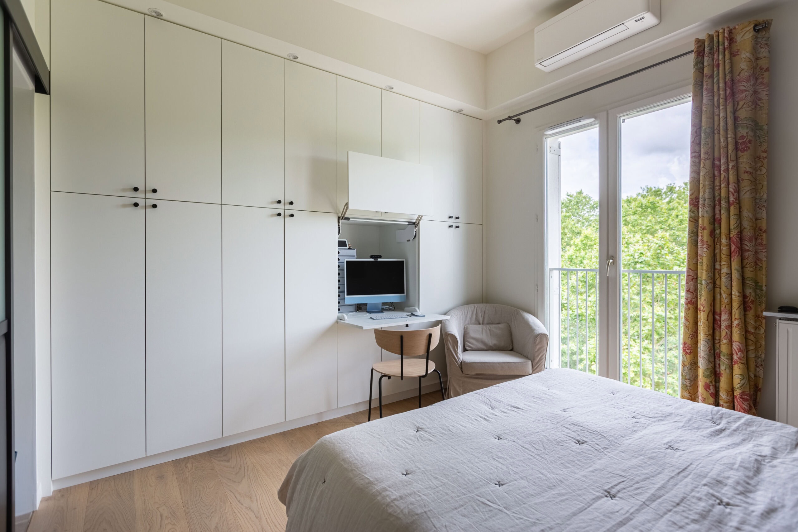 Chambre moderne avec bureau escamotable intégré dans un grand placard