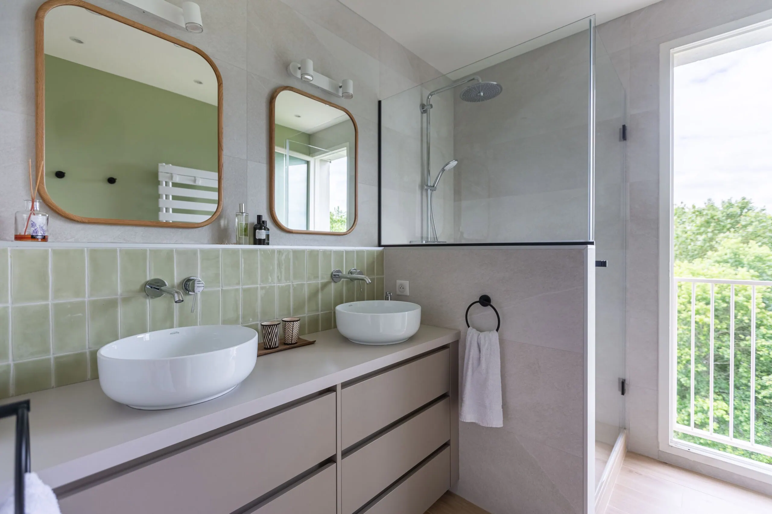 Salle de bain avec double vasque, miroirs en bois et douche à l’italienne avec paroi vitrée