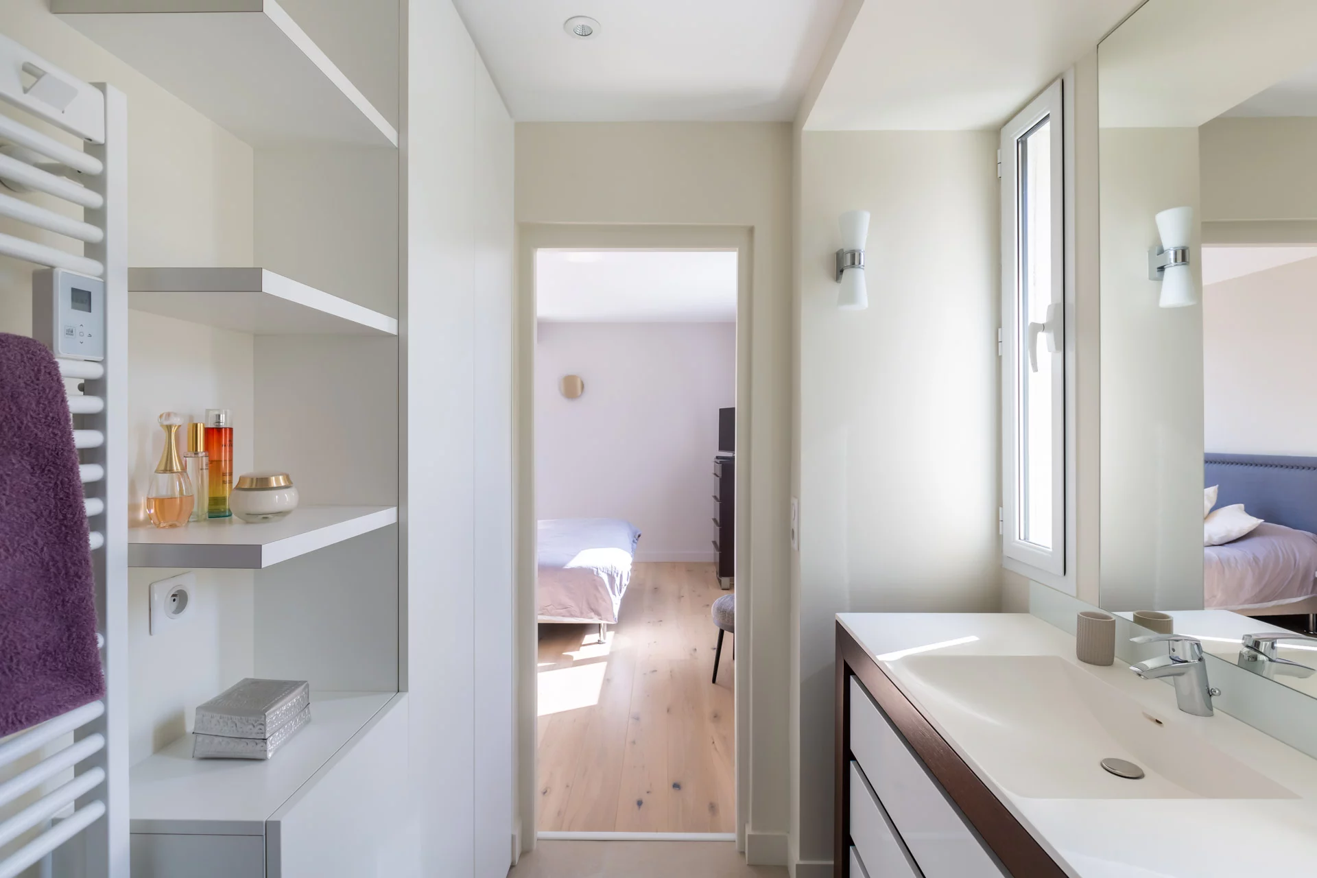Salle de bain contemporaine avec rangements ouverts et meuble vasque moderne.